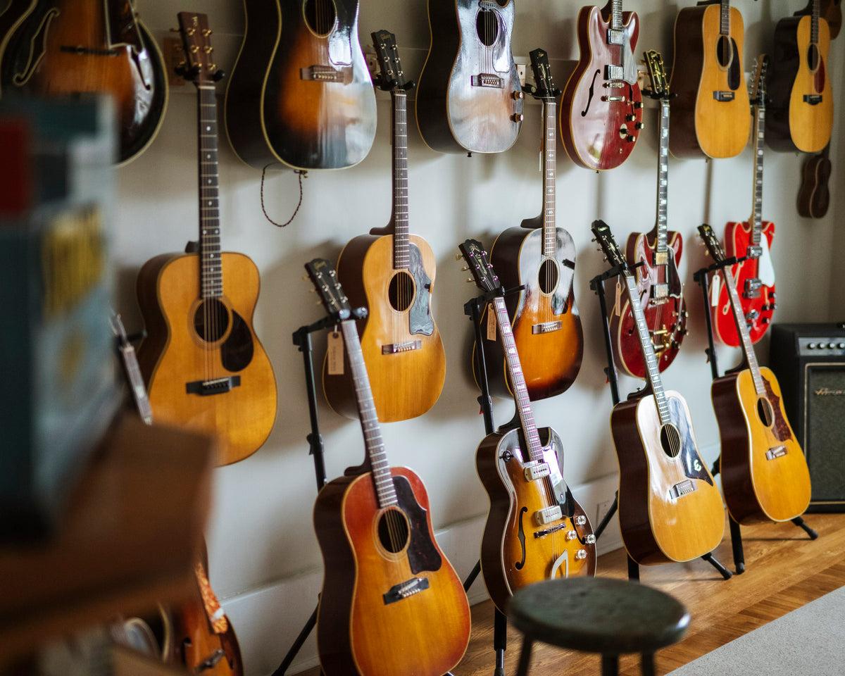 Wall displaying various vintage guitars in a music store