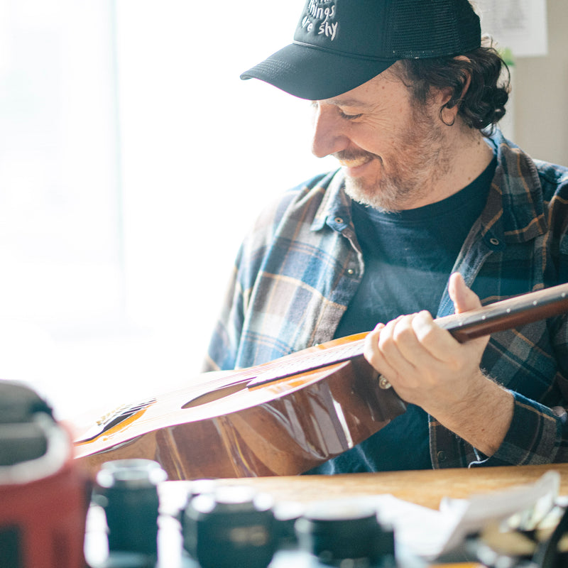 Man playing an acoustic guitar in a casual setting